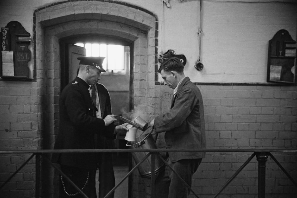 Prison officer Davidson serving a prisoner a meal at Strangeways Prison.