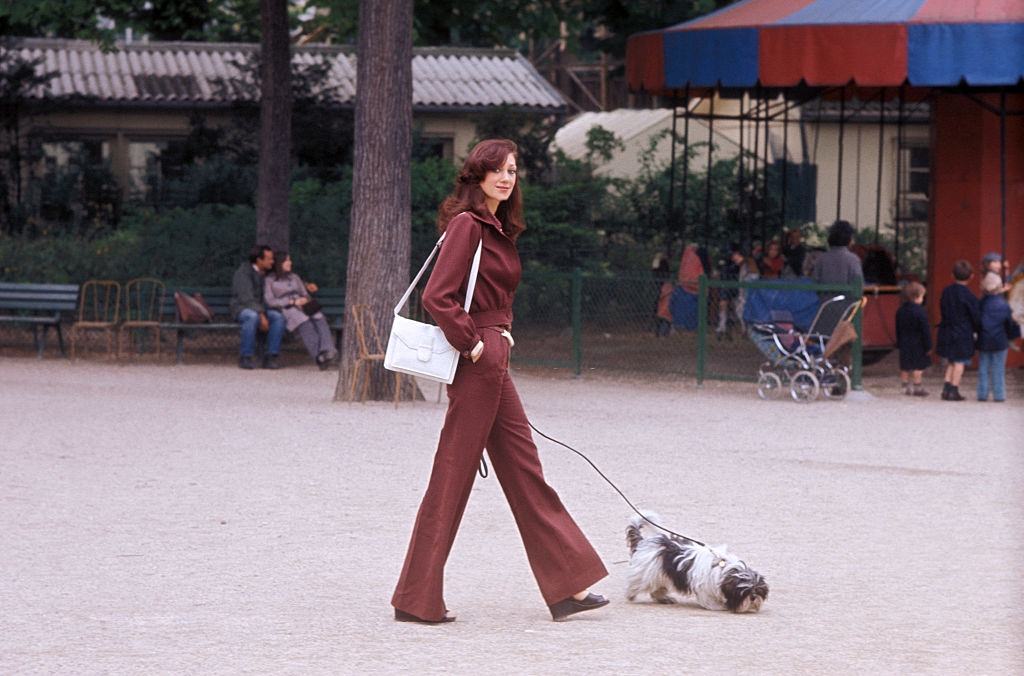 Marisa Berenson walking with her dog.