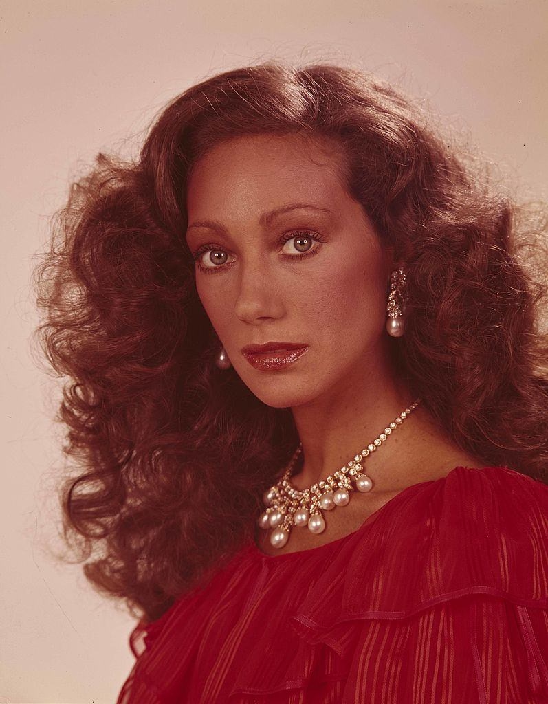 Marisa Berenson, wearing a necklace and pearl earrings.