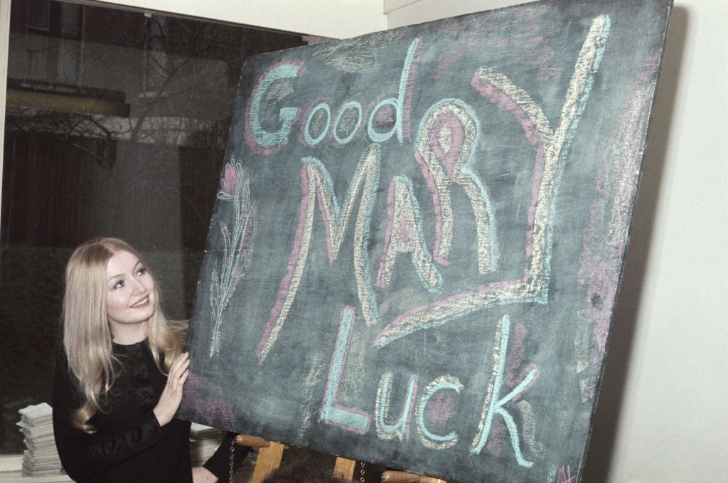 Mary Hopkin, who is representing the United Kingdom in the 1970 Eurovision Song Contest, with a sign reading 'Good Luck Mary', 1970.