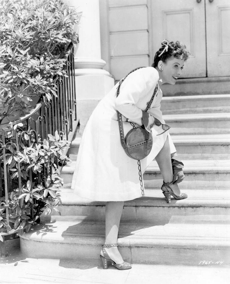 Paulette Goddard adjusting the strap on her shoe in a scene from the movie, 'Star Spangled Rhythm', 1942.