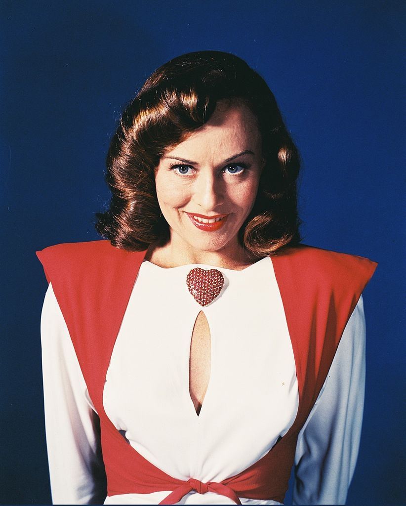 Paulette Goddard wearing a red-and-white blouse, with a keyhole neckline, and a large red heart-shaped brooch, 1945.