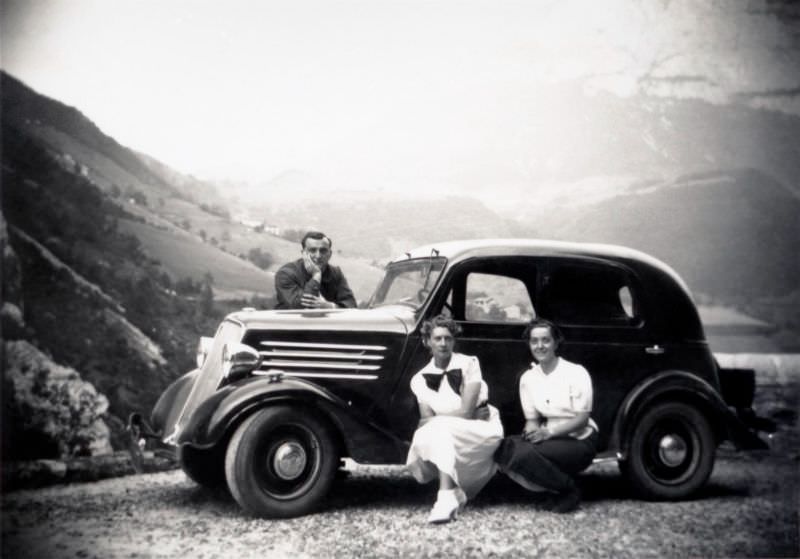 Two stylish ladies and a fellow in a suit posing with a Renault Celtaquatre in an Alpine landscape, 1935