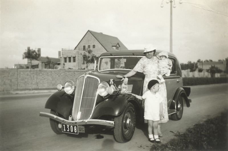 A mother and her two children posing with a Renault Monaquatre, circa 1936