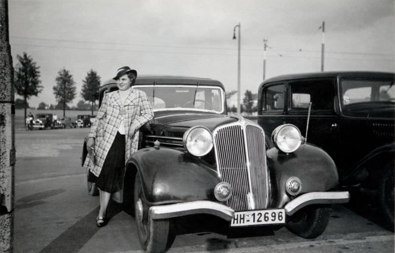 An elegant lady posing with a Renault Vivastella on the outskirts of town in late afternoon sunshine, 1938