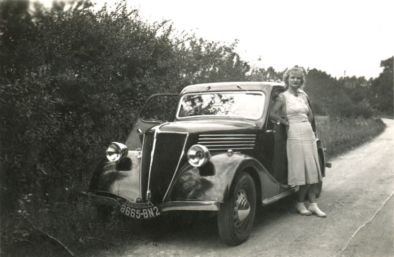 A young lady in a white dress seductively posing with a Renault Celtaquatre, 1939