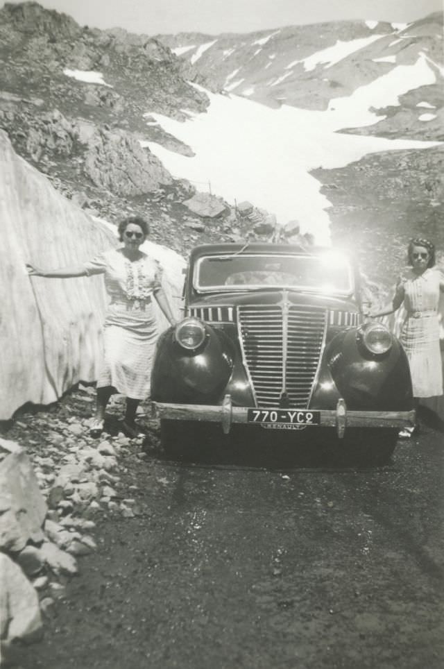 Two ladies in white dresses posing with a Renault Suprastella on an Alpine Road. The car is registered in the French département of Seine et Oise, 1939