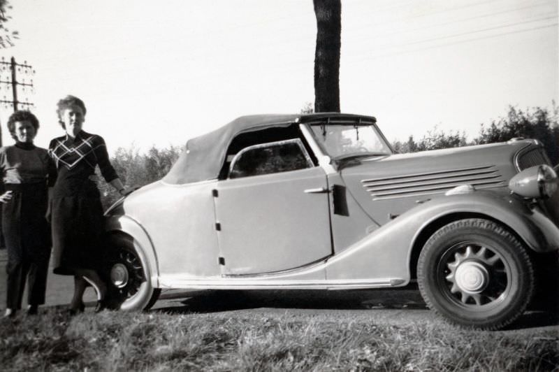 Two ladies posing with a Renault Monaquatre Cabriolet-Spider convertible in the countryside, 1948