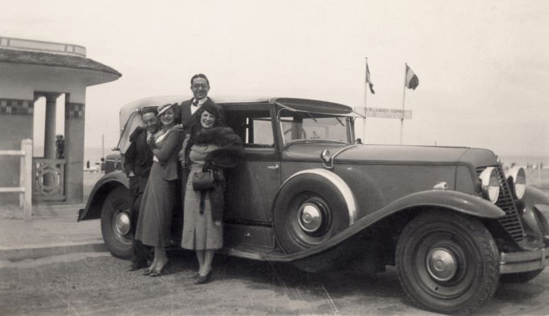 Two couples posing with a Renault Reinastella at the seaside, 1930