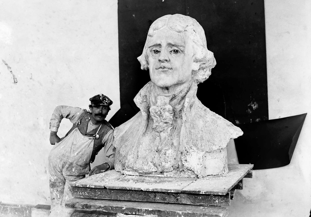 A craftsman stands by a bust of Thomas Jefferson, the model for the statue by Charles Grafly installed at the Louisiana Purchase Exposition.