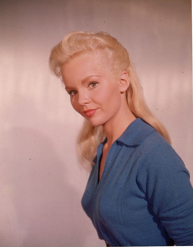 Tuesday Weld smiling and wearing a blue button-down shirt, 1960.