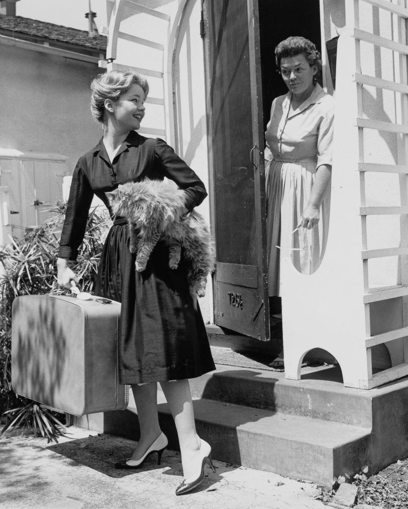 Tuesday Weld, holding her longhaired cat and a suitcase, leaves home to start her career in Hollywood as her mum, 1955.