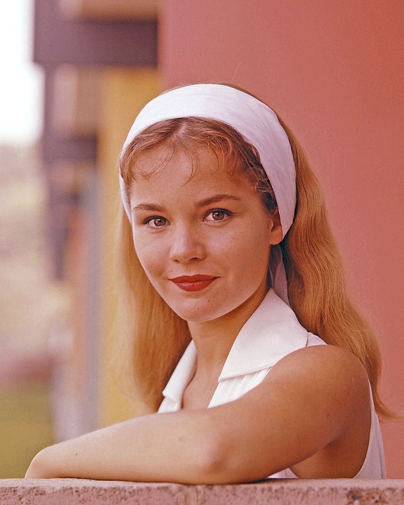 Tuesday Weld wearing a white sleeveless top and a thick white headband, circa 1965.