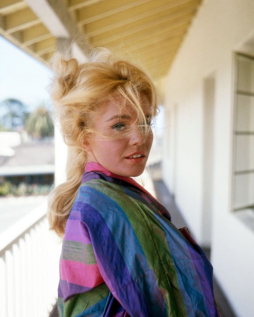 Tuesday Weld, in a striped top, as she poses on a windy balcony, 1960s.