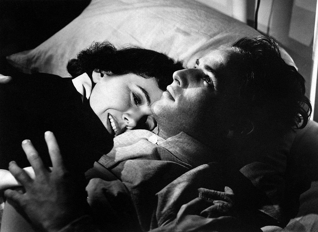 Marlon Brando embracing American actress Teresa Wright on a bed, 1950.