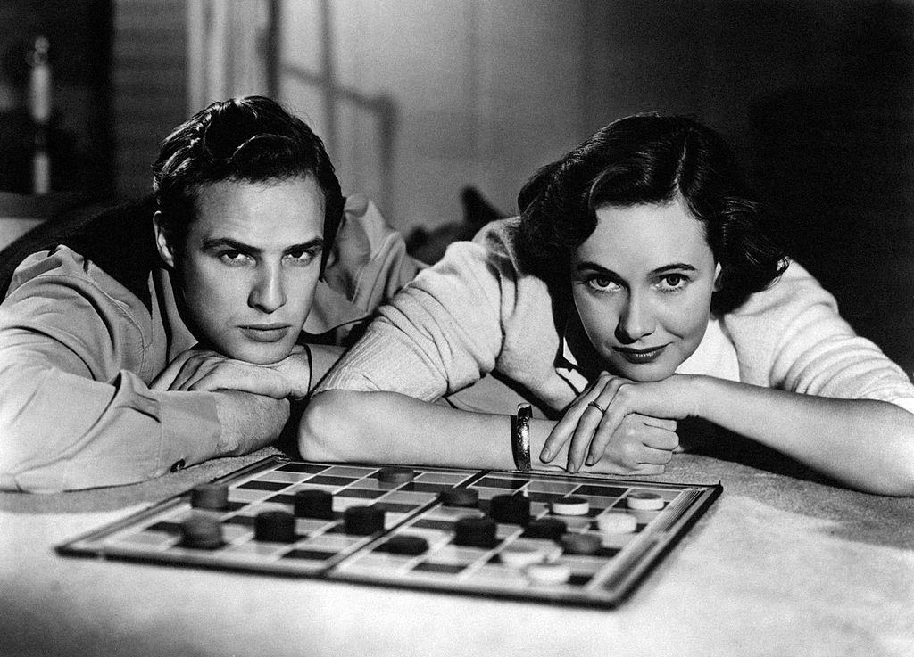 Marlon Brando with Teresa Wright posing in front of a chessboard in the film 'The Men', 1950.
