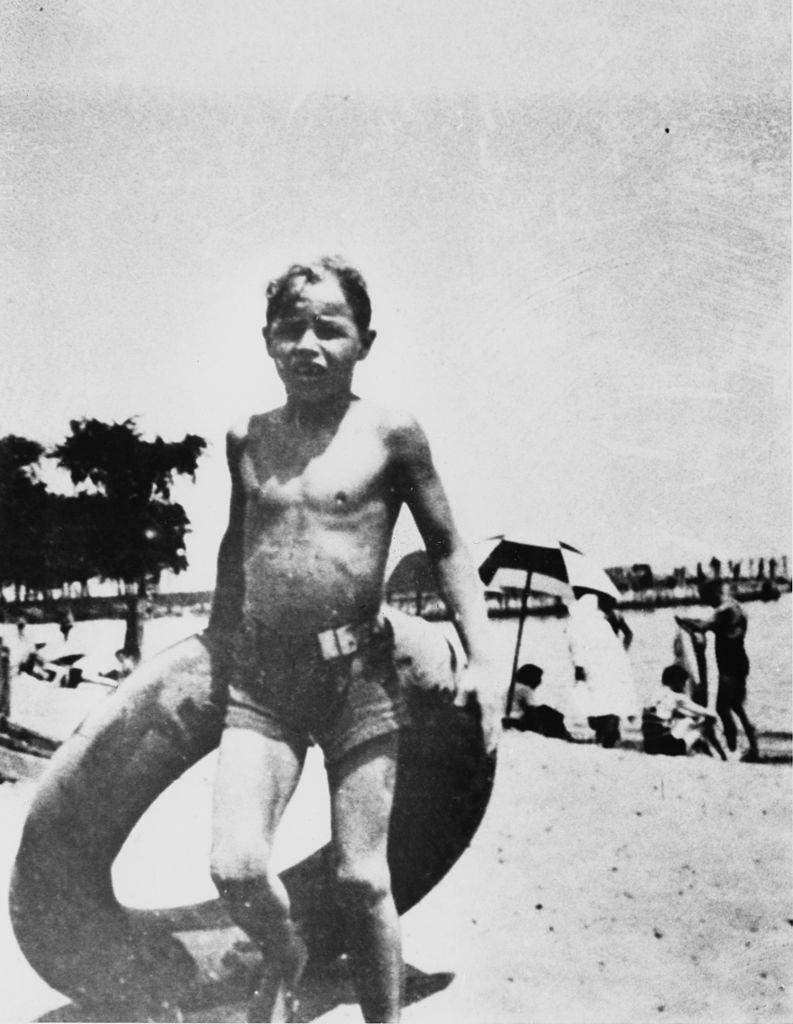 Marlon Brando holding an inflatable ring during a trip to a beach, 1932.