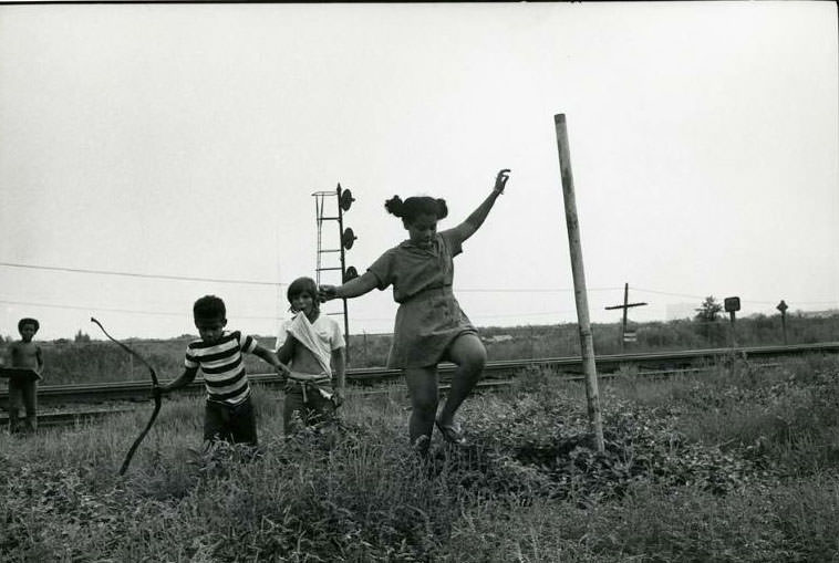 Four children playing by the railroad tracks next to the Jefferson Park Housing Project, Jefferson Park, 1973