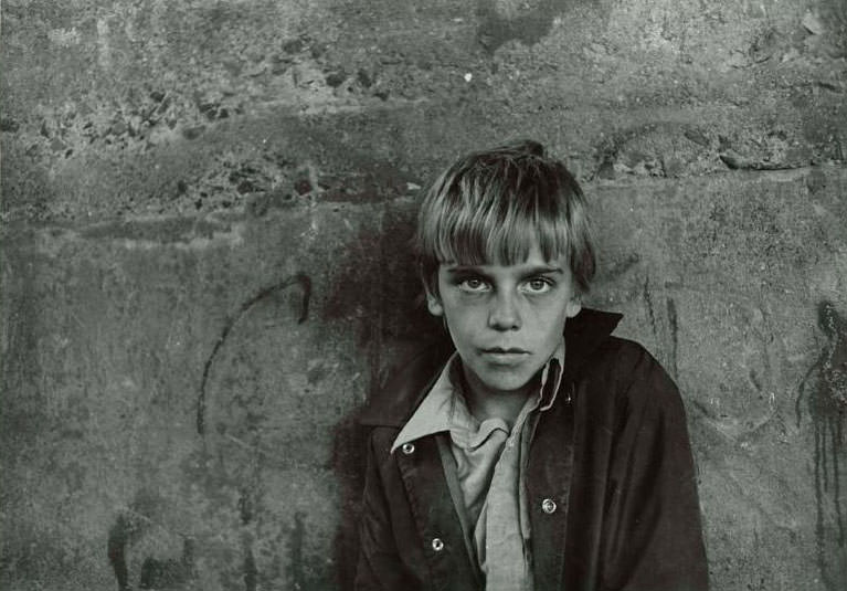 Close up of a boy named Rico standing against a concrete background, Jefferson Park, 1974