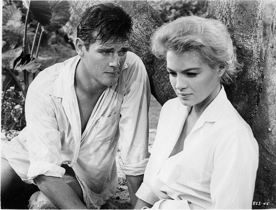 Roger Moore leaning towards Angie Dickinson in a scene from the film 'The Sins Of Rachel Cade', 1958.