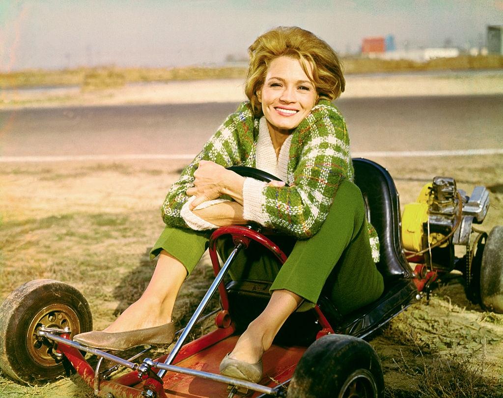 Angie Dickinson sitting in go-cart, 1960.