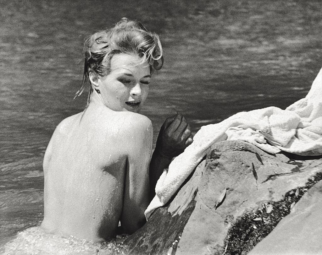 Angie Dickinson taking a bath leaning on a cliff., 1961.