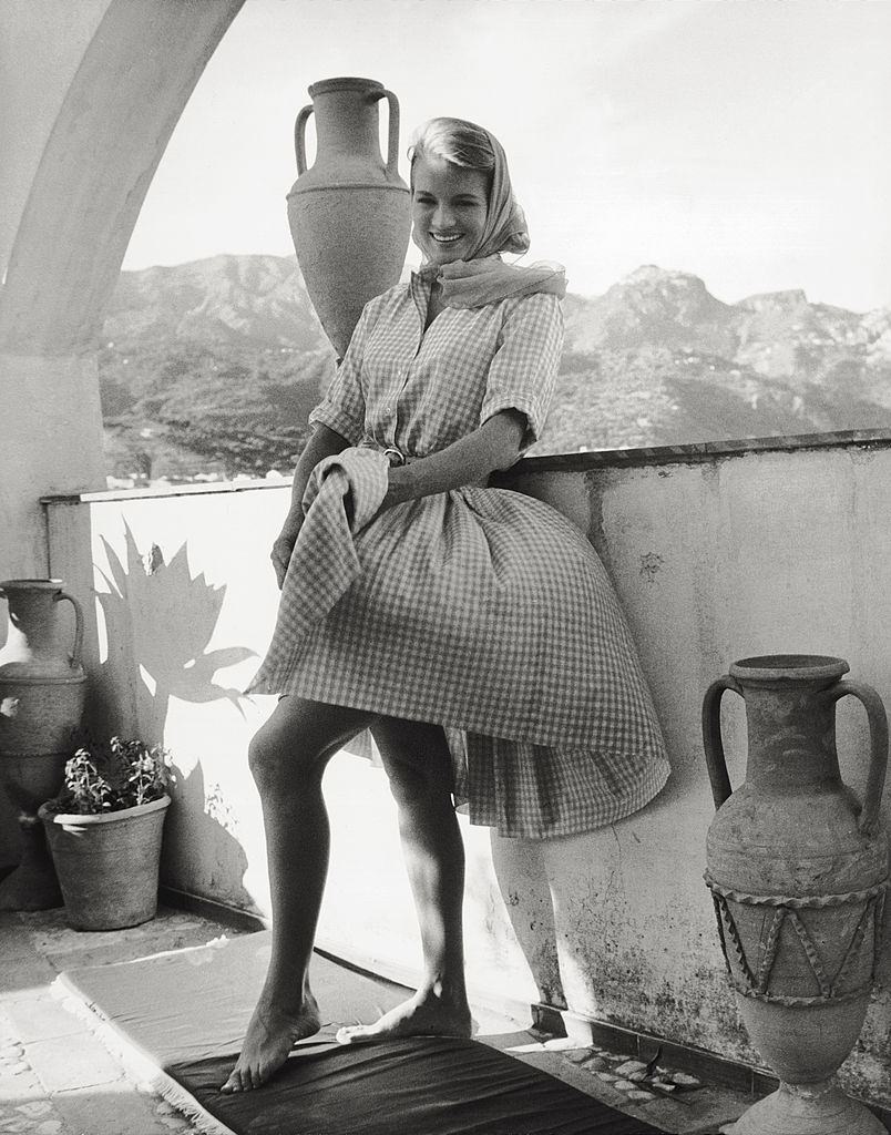 Angie Dickinson smiling while the wind whips up her dress on a terrac, 1961.