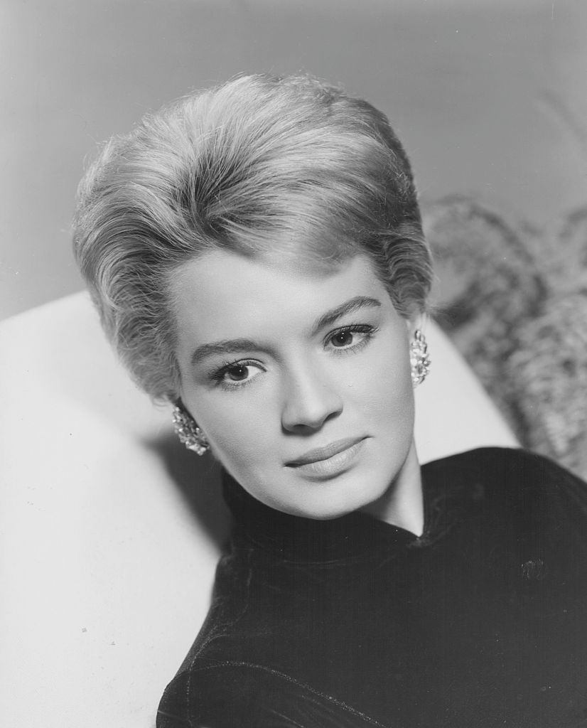 Angie Dickinson, wearing a high necked blouse and earrings, 1955.