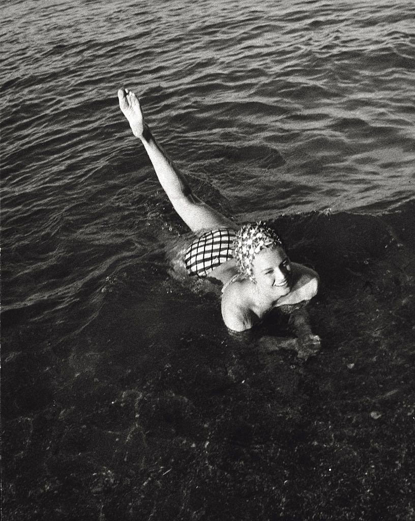 Angie Dickinson taking a bath near the shore, 1961.