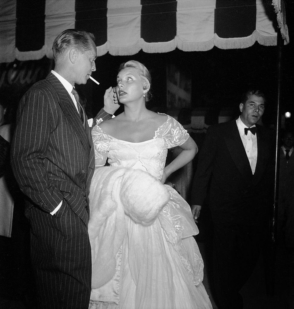 Barbara Payton with Franchot Tone waiting outside Mocambo nightclub, 1951.