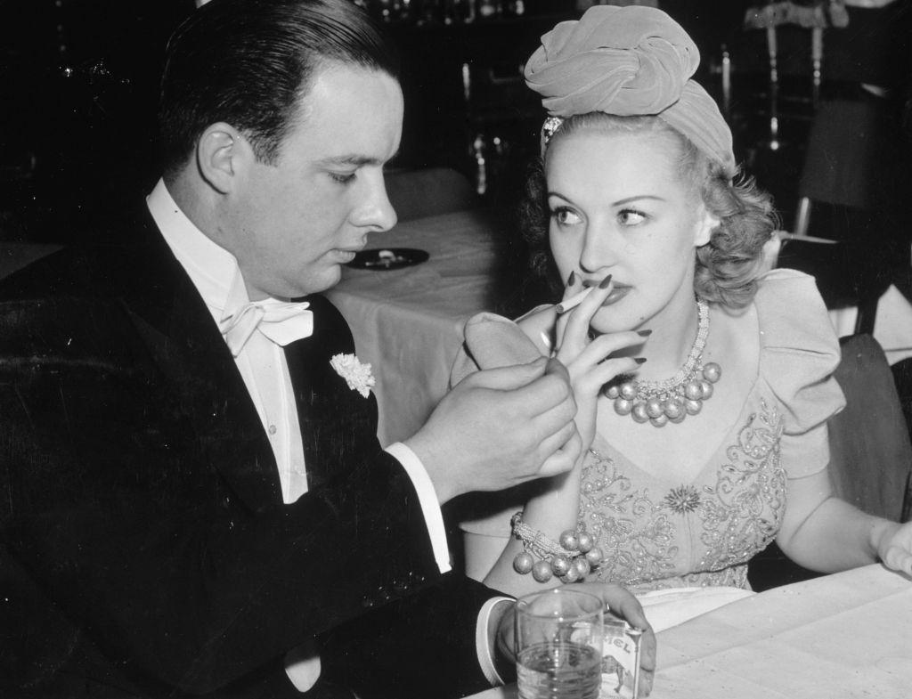 Bob Crosby lights a cigarette for Betty Grable, 1935.