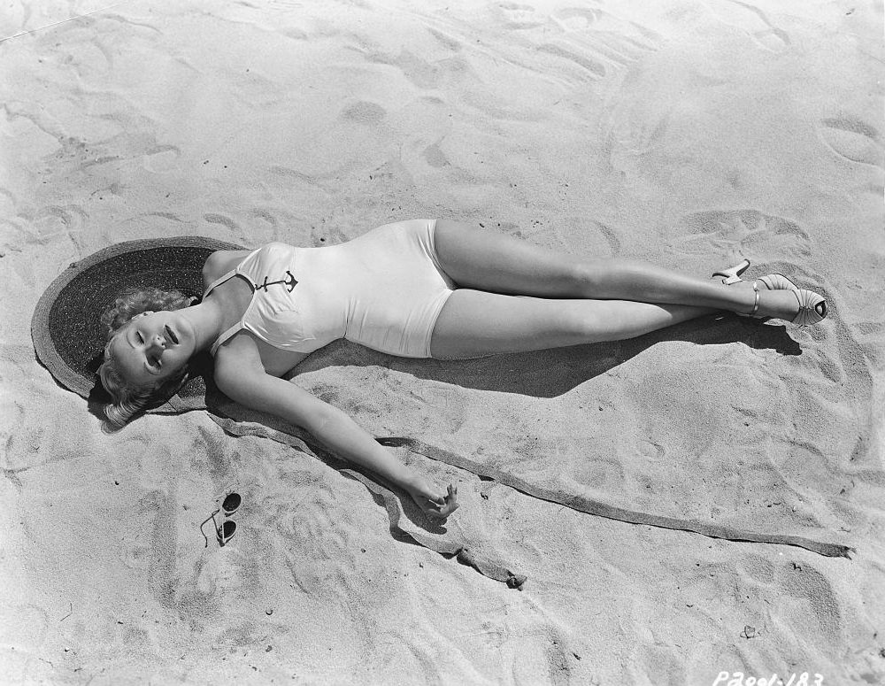 Betty Grable relaxing on the beach, 1937.