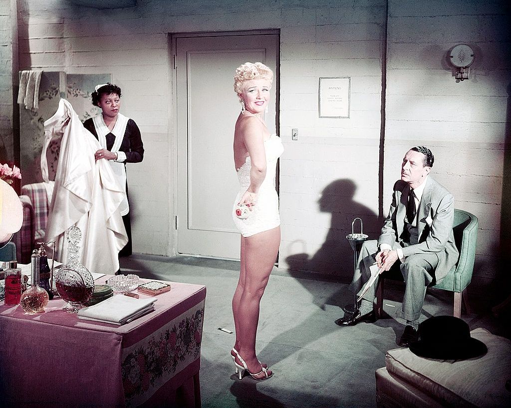 Betty Grable wearing a one-piece swimsuit in a dressing room, 1945