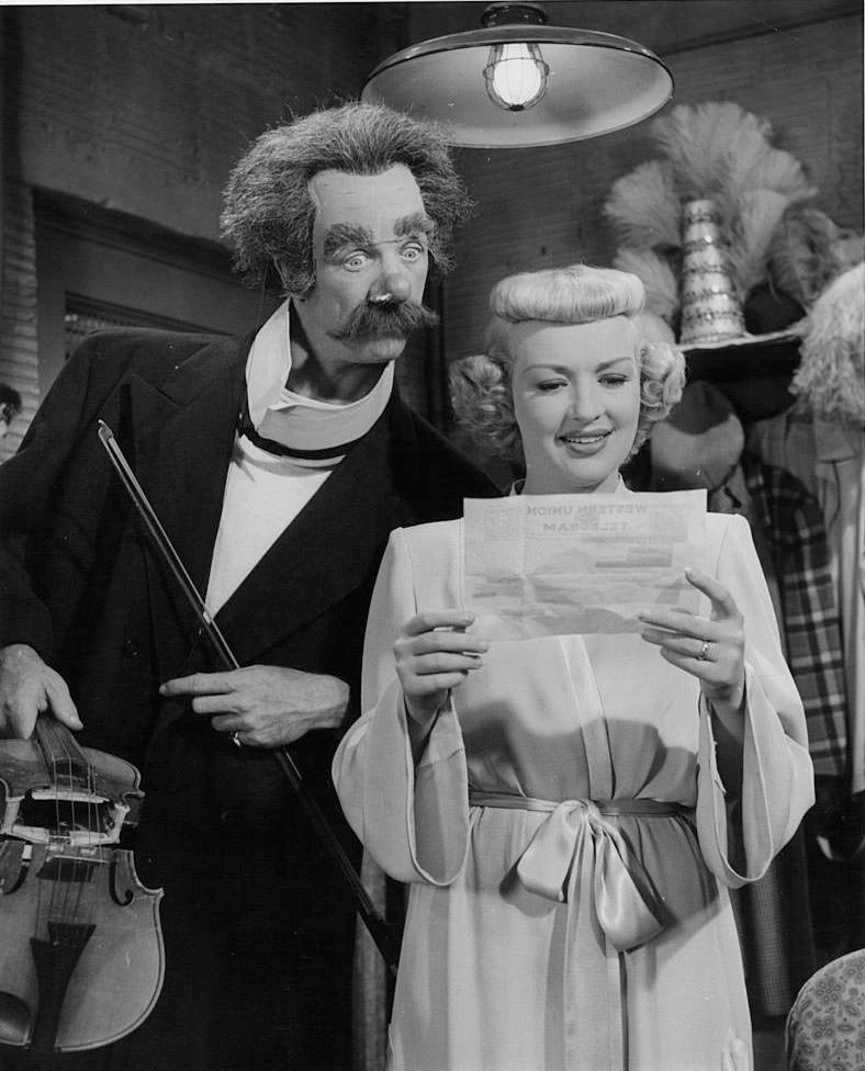 Betty Grable reading a telegraph while Dan Dailey is look it, 1948.