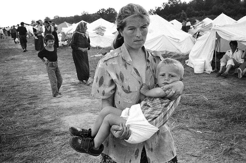 A Muslim mother carries her child at a refugee camp set up at Tuzla airport.
