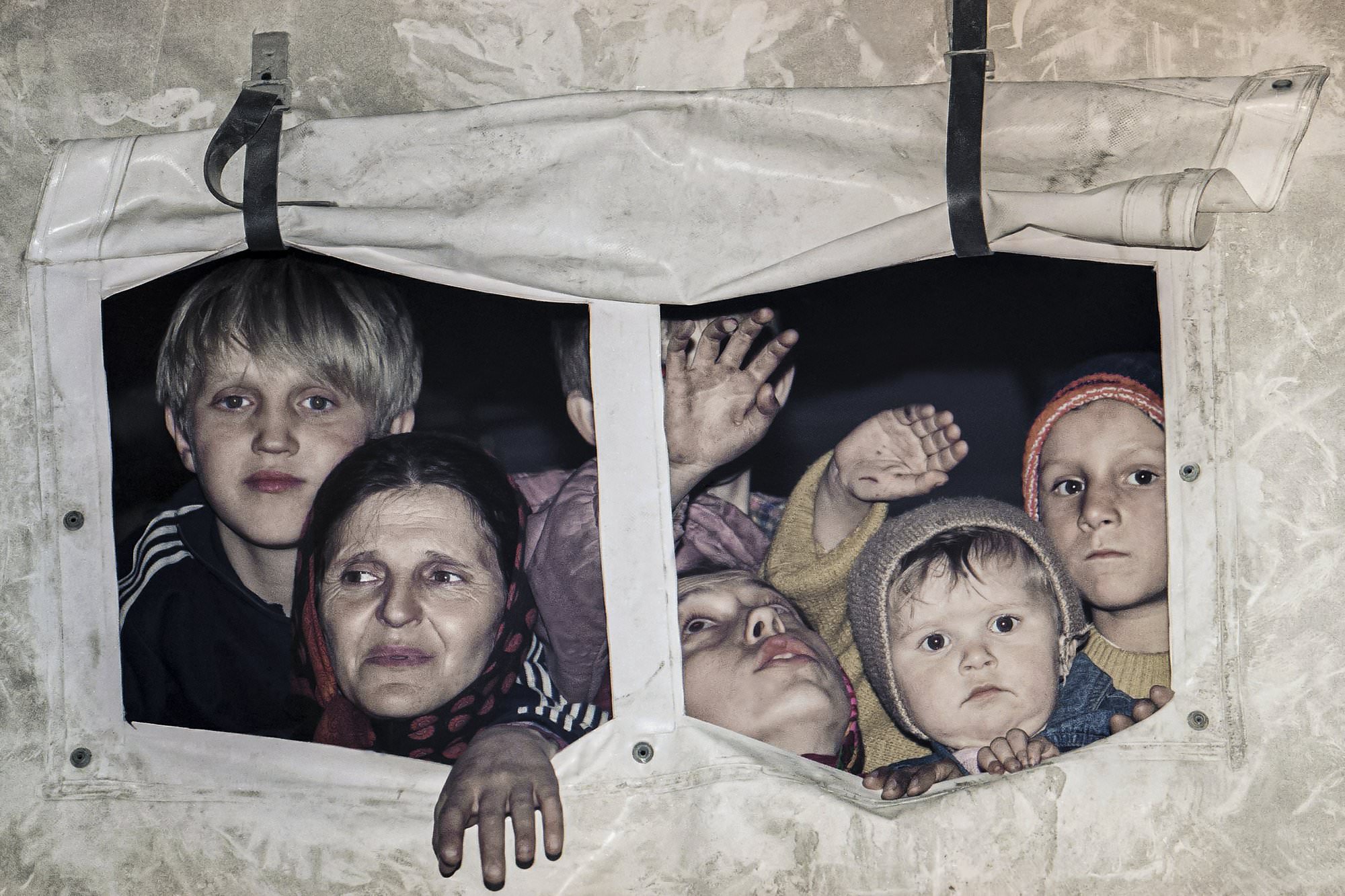 Evacuees form Srebrenica look out from a U.N. truck in Medgas, Bosnia, north of Sarajevo, as a U.N. truck convoy carrying people from the besieged Bosnian town made its way to Tuzla, March 20, 1993.