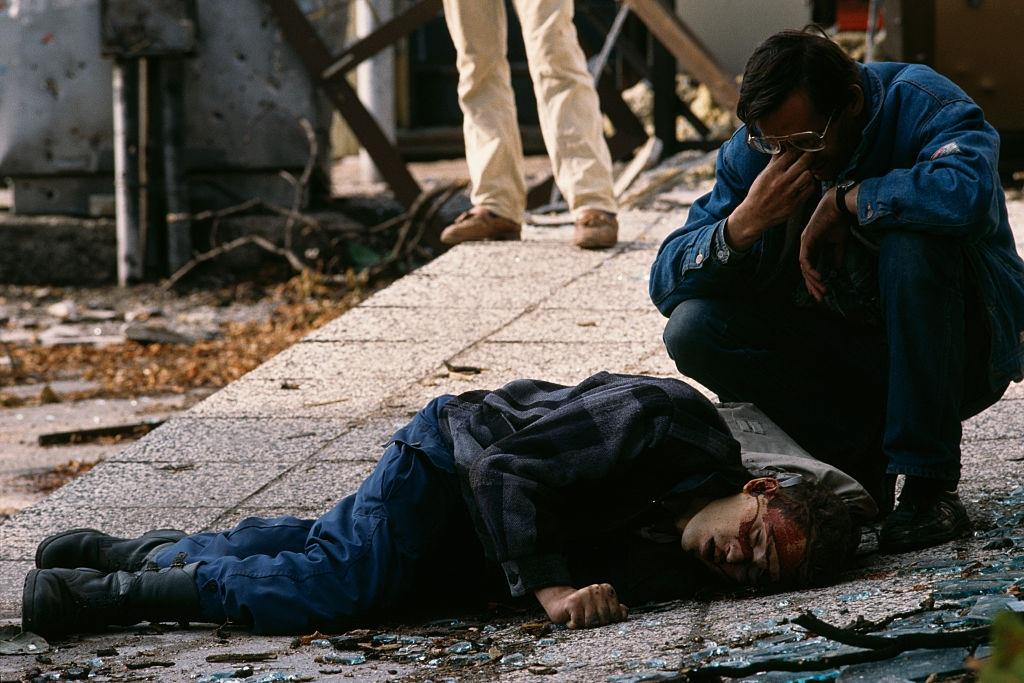 A man mourns next to the body of a civilian victim of the siege of Sarajevo who was killed by a sniper.