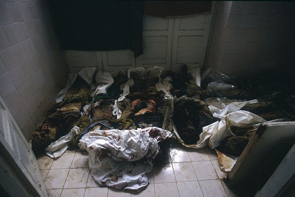 The corpses of civilians killed during the siege of Sarajevo lie on the floor of a morgue in Sarajevo. Some bodies are still in their clothes while others are wrapped in sheets.
