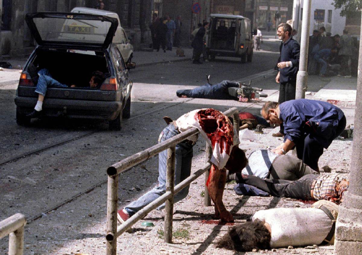 Dead and wounded people lie scattered outside Sarajevo's indoor market after a mortar shell exploded outside the entrance to the building, on August 28, 1995.