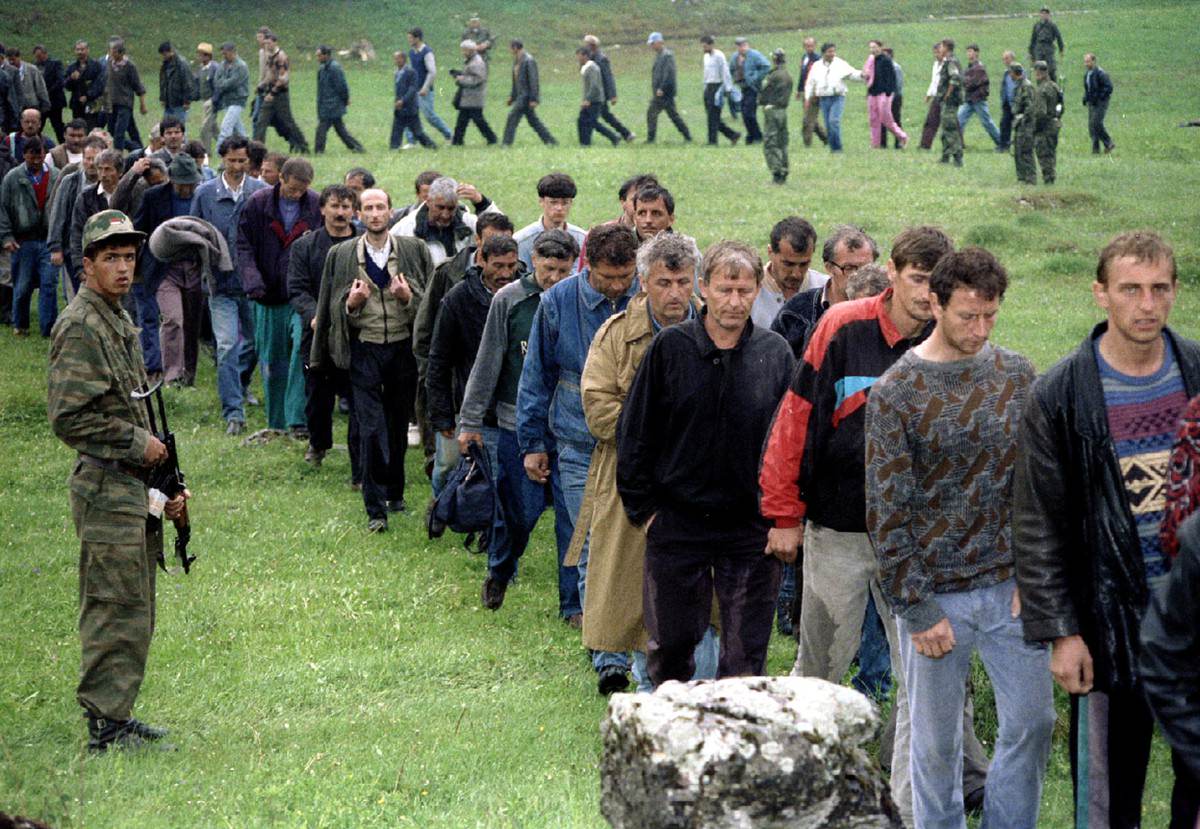 Bosnian Croat soldiers taken as prisoners pass a Bosnian Serb soldier after surrendering on the central Bosnian mountain of Vlasic June 8.