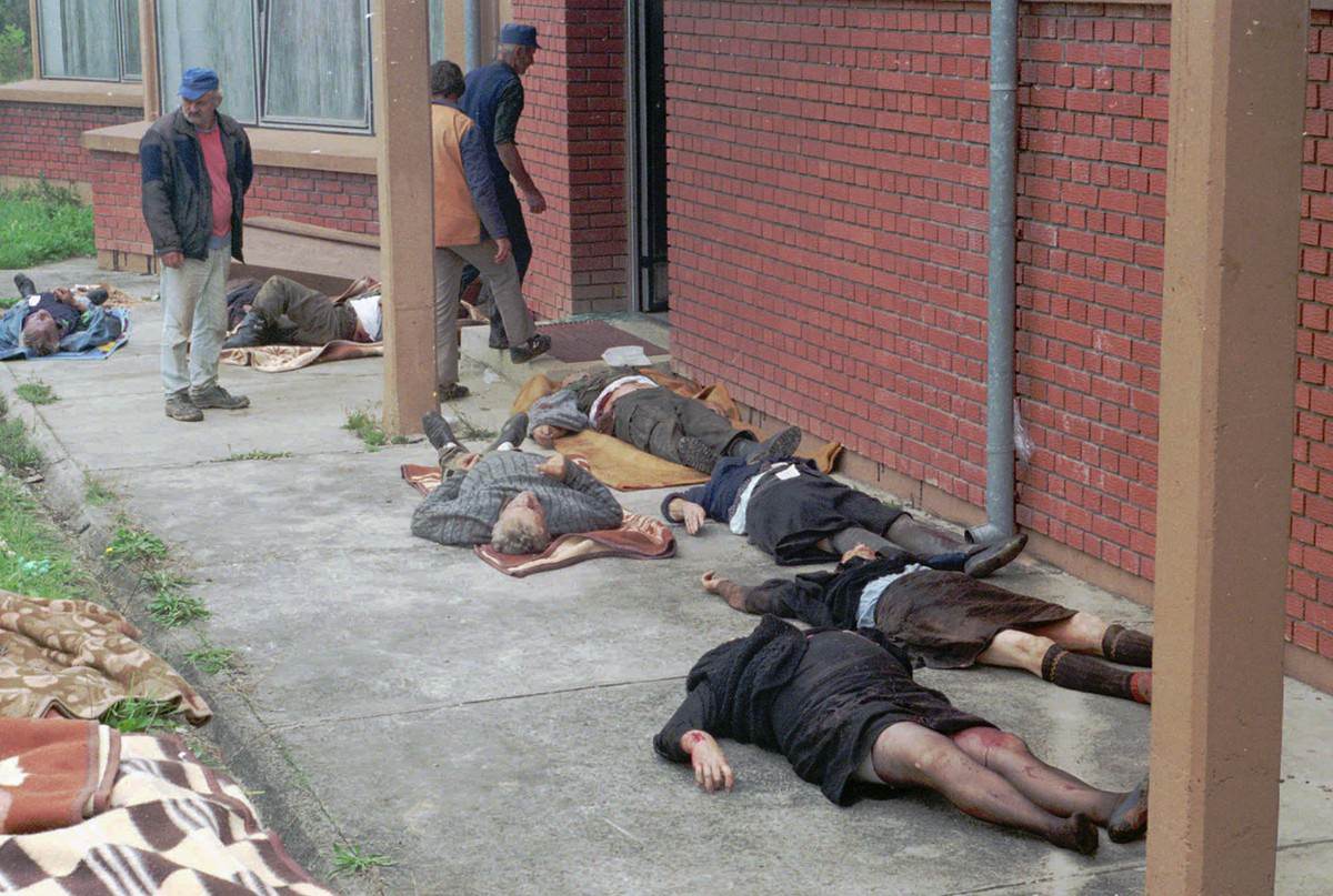 People look at bodies of Serb civilians allegedly killed in a Croatian Army commando raid in the town of Bosanska Dubica, some 250 kilometers (155 miles) west of Sarajevo, on September 19, 1995.