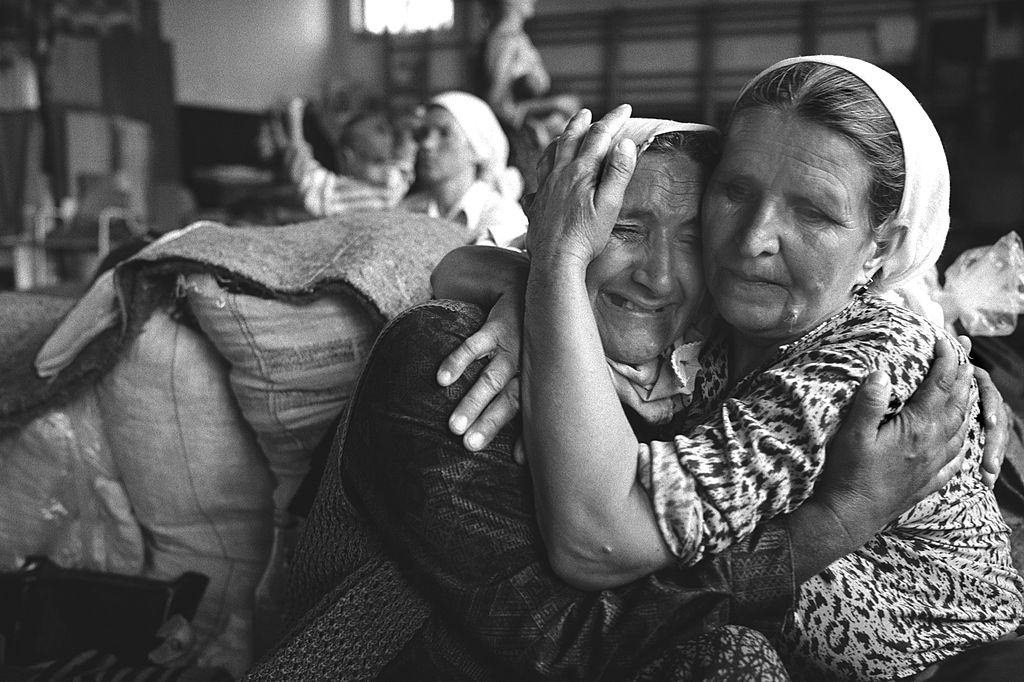 Grieving elderly Muslim women pictured in a refugee centre set up to shelter Muslim families after they fled Srebrenica.