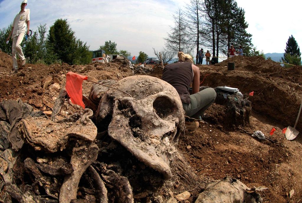 Forensic experts work in a mass grave in the village of Budak, located some two-and-a-half kilometers from a memorial center for the massacre victims