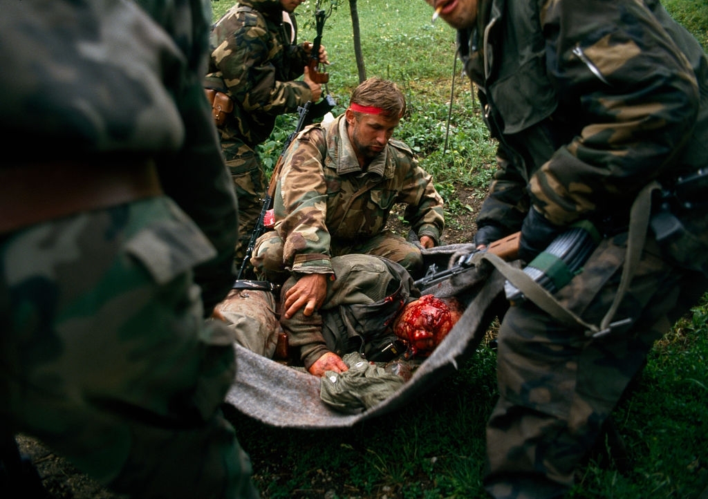 Muslim Bosnian soldiers assist an injured friend on the eastern frontline of Bandol in the Yugoslavian Civil War.