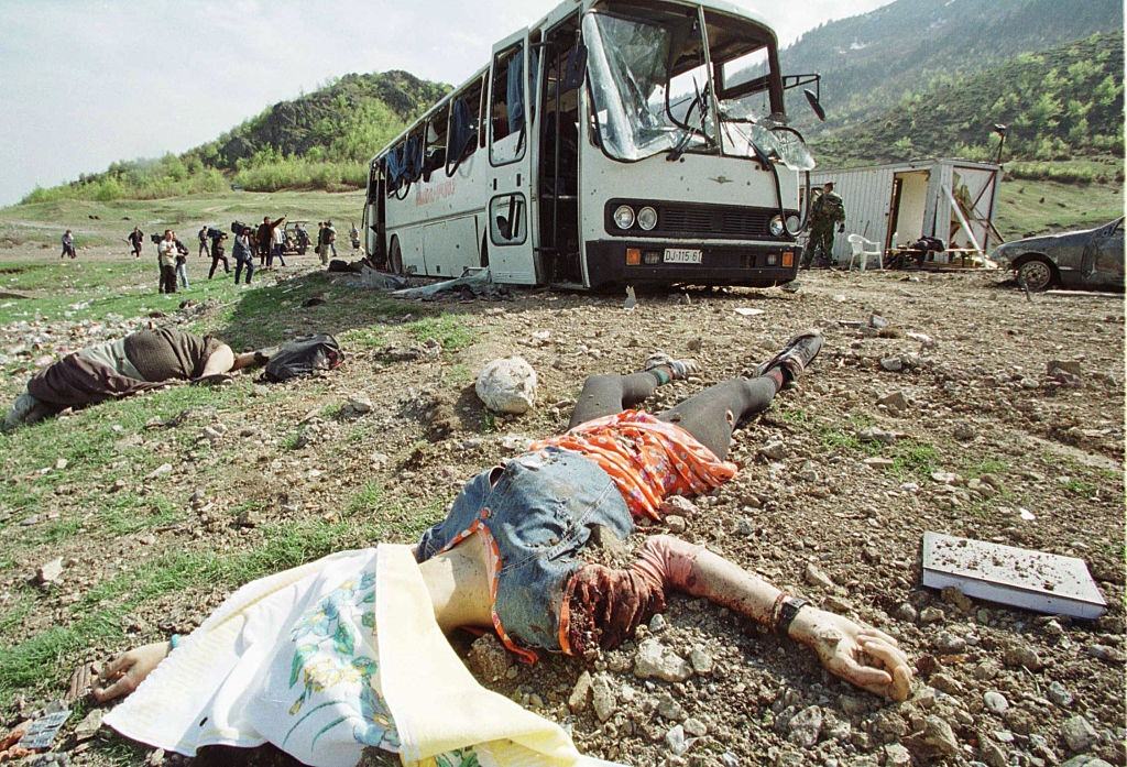 Bodies in front of the shell of the bus.