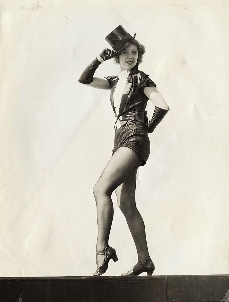 Eleanor Powell finishes her 'warmin' up' routine by strutting off the stage with a quizzical look.