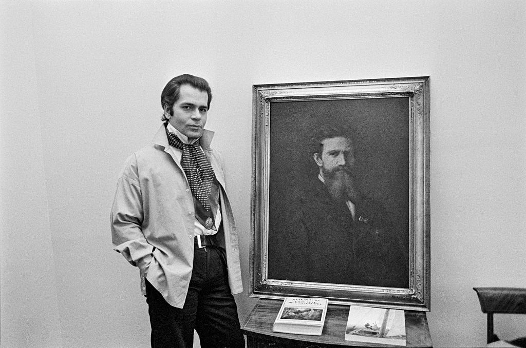 Karl Lagerfeld posing with a painting, 1976.