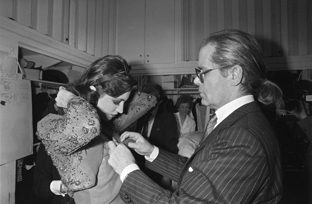 Karl Lagerfeld with a model ahead of the presentation of spring-summer haute couture collection for Chanel in Paris, 1983.