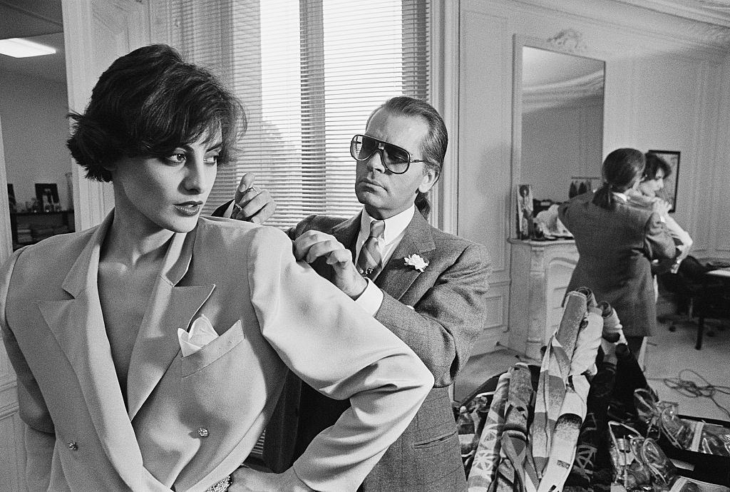 Karl Lagerfeld fits one of his designs on top model Ines de la Fressange at Chloe's Paris studio.