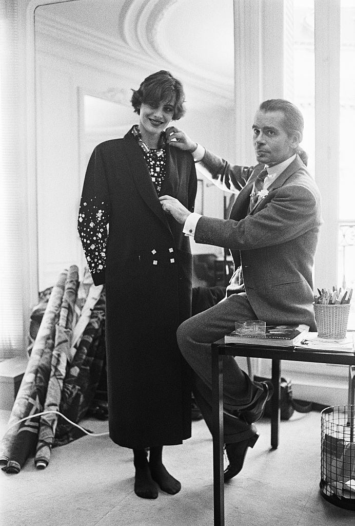 Karl Lagerfeld fits one of his designs on top model Ines de la Fressange at Chloe's Paris studio.